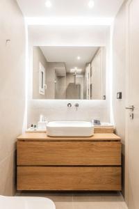 a bathroom with a sink and a large mirror at Downtown Urban Luxurious Apartment in Athens