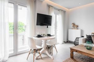 a white living room with a table and chairs at Downtown Urban Luxurious Apartment in Athens