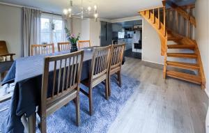 a dining room and kitchen with a table and a staircase at Amazing Home In Kinnahult With Wifi in Kinnahult