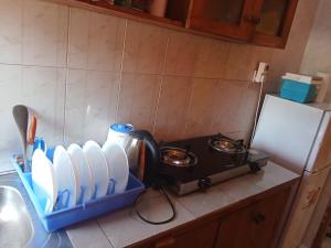a kitchen counter with a coffee pot and white dishes at Magical Fharhana House in Malindi