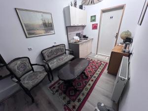 a living room with two chairs and a table at Prenoćište Jocic in Pirot