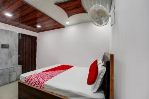 1 dormitorio con 1 cama y ventilador en el techo en OYO The Mid Town Inn, en Patna
