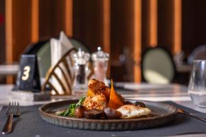 a plate of food on a table at a restaurant at Hotel Carpathia in Sinaia