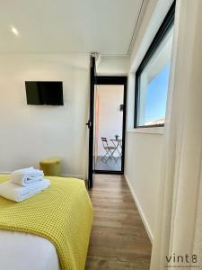 una camera con letto giallo e finestra di Casa do Golfe by VinteOito ad Amarante