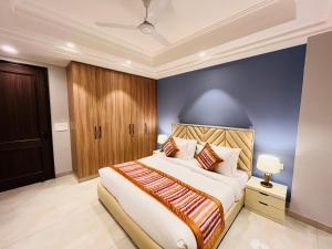 een slaapkamer met een groot bed en een blauwe muur bij Hotel Gianmala Residency South Extension near AIIMS Delhi in New Delhi