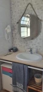 a bathroom with a white sink and a mirror at Casa Isa By Natasha Gomes in Almograve