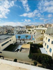 Cette chambre offre une vue sur un bâtiment doté d'une piscine dans une ville. dans l'établissement Crystal boulevard, à Tanger