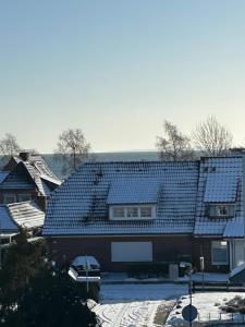 una casa con techos azules en la nieve en Küstenbude Ostseeblick, en Grömitz