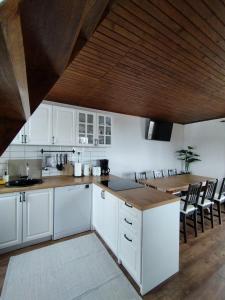 cocina con armarios blancos y techo de madera en Countryside cottage with mountain view, en Lukovica pri Domžalah