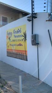 un cartel en el lateral de un edificio con un cartel de hotelería feliz en Happy Hostel e Pousada Paracuru en Paracuru