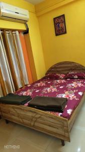 a bedroom with a wooden bed with at Mauli Cottage in Kashid