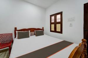 a bedroom with a bed and a window at Collection O CHITRA LODGE 