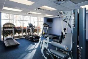 a gym with several tread machines in a room at #1807 Big Heated Pool, Sunrise, Lake, Disney views in Orlando