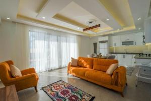 Villa Atalar في كيمير: غرفة معيشة مع كنب برتقالي ومطبخ
