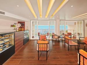 comedor con sillas, mesa y ventanas en The Cliff Resort & Spa, Panchgani, en Panchgani