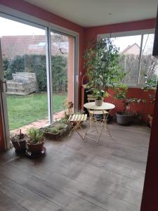 a patio with a table and chairs and potted plants at Les stands 4 chambres - lits doubles in Teloché +8 photos