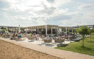 un resort con persone sedute su un patio con sedie di Neilson Messini Activity Beach Club a Kalamáta