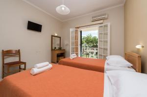 a hotel room with two beds and a window at Olga Studios - 1 in Tsilivi