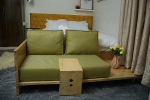 un sofá con almohadas verdes y una mesa en una habitación en ENz Lovely Apartment 9, en Bungoma