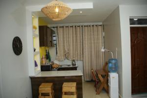 cocina con encimera, mesa y lámpara en ENz Lovely Apartment 9, en Bungoma