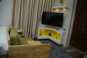 sala de estar con TV y sofá en ENz Lovely Apartment 9, en Bungoma