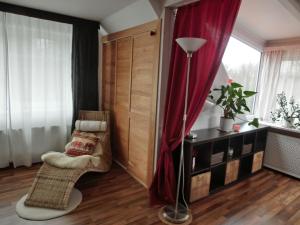 een woonkamer met een rood gordijn en een stoel bij Auftanken im Grünen _ just4you_b.Berlin in Neuenhagen