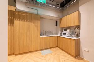 a kitchen with wooden cabinets in a room at Bluewaters Pods 11 North Canal Road in Singapore