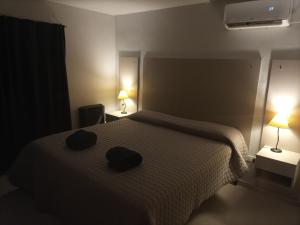 Un dormitorio con una cama con dos sombreros. en CASA QUINTA CON PILETA, GALERIA, IMPECABLE , AIRE, WIFI en Santa Rosa