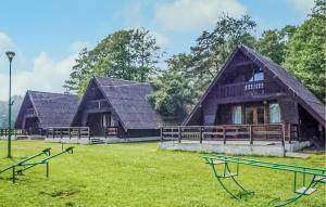 two large wooden buildings with a grassy field in front at Amazing Home In Mielno With Kitchen in Mielno