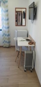 a room with a table and a radiator and a mirror at Casa Isa in Almograve