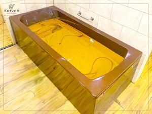 bañera con líquido amarillo en el baño en Karvan Hotel Naftalan, en Naftalan