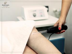 a woman in a hospital room with her leg on a machine at Karvan Hotel Naftalan in Naftalan