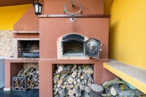 um forno exterior com uma pilha de lenha em Casa Rural "compartida" La Loma em Granada