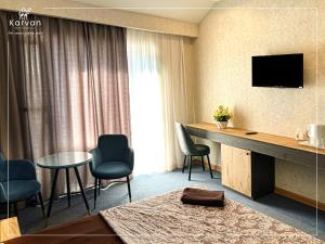 a hotel room with a table and chairs and a television at Karvan Sanatorium Naftalan in Naftalan