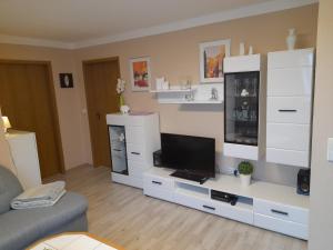 a living room with a television and white cabinets at Haus Roßner in Nemmersdorf