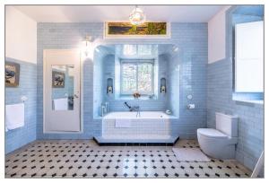 a blue bathroom with a tub and a toilet at Finca Villa Ángeles in San Rafael