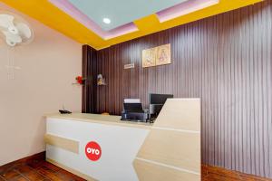 an office with a reception desk with a yellow ceiling at OYO Flagship The Imperial Inn in Patna