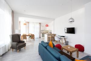 a living room with a blue couch and a kitchen at Gutshaus Wohnung 1 in Laschendorf