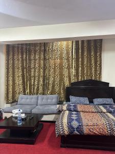 a living room with a couch and a bed at Islamabad lodges apartment suite in Islamabad