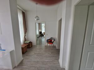 a room with a hallway with a chair and a table at Gutshaus Wohnung 1 in Laschendorf