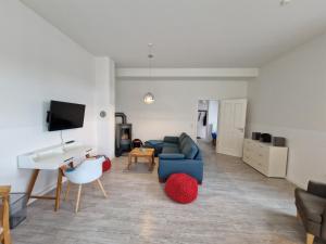 a living room with a blue couch and a sink at Gutshaus Wohnung 1 in Laschendorf