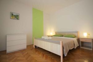 ポレッチにあるApartment in Porec with Two-Bedrooms 10の緑の壁とウッドフロアのベッドルーム1室