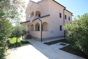 duży biały budynek z drzewami przed nim w obiekcie Apartment in Porec 10 w Poreču