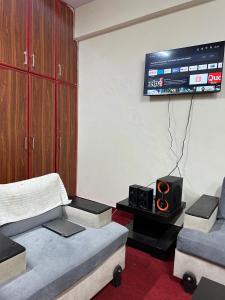 uma sala de estar com 2 sofás e uma televisão de ecrã plano em Islamabad lodges apartment suite em Islamabad
