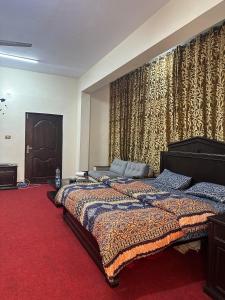 a bedroom with a large bed and a red carpet at Islamabad lodges apartment suite in Islamabad