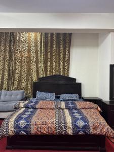 a bedroom with a bed with a colorful comforter at Islamabad lodges apartment suite in Islamabad