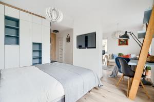 een witte slaapkamer met een bed en een bureau bij Apartament Pułaskiego z garażem in Toruń