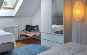 ein Schlafzimmer mit einem Bett, einem Stuhl und einem Spiegel in der Unterkunft Amazing Apartment In Dargocice With Wifi 
