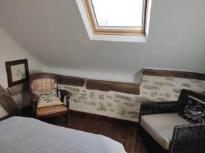 a bedroom with a bed and a chair and a window at Les Hirondelles et la glycine in Montréal