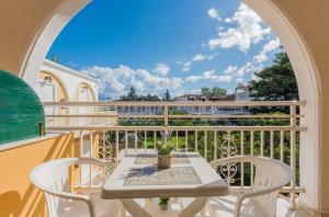 a table and chairs on a balcony with a view at Olga Studios - 1 in Tsilivi +13 photos